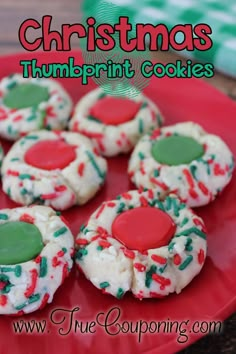 there are many decorated cookies on the red plate with white and green icing,