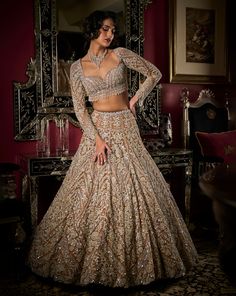 This lehenga set features intricate silver embroidery in sequin, crystal and glass beads. The blouse shows heavy beaded tassels at the waist and wrist. It is paired with a matching all over worked dupatta with crystal drop detail. DELIVERY TIMEPlease allow 8-12 weeks for your outfit to arrive. FABRIC DETAILSLehenga - Net / Dupatta - Net Professional cleaning only. Silver Lehenga, Over Worked, Peach Lehenga, Sequin Lehenga, Seema Gujral, Heavy Lehenga, Sangeet Outfit, Bridal Lehenga Designs, Latest Bridal Lehenga