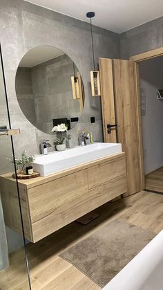 a bathroom with a sink, mirror and bathtub in the middle of the room