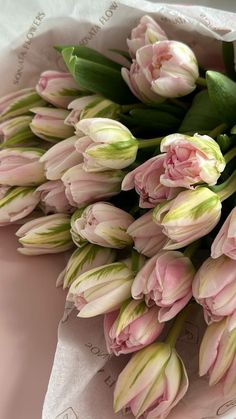 a bouquet of pink tulips sitting on top of a table