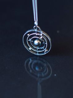 Solar System 925 Sterling silver Spinning Pendant by MirielDesign Sterling Silver Celestial Necklace With Polished Finish, Sterling Silver Sphere-shaped Jewelry, Modern Spiral Sterling Silver Jewelry, Spiral Sterling Silver Jewelry With Oxidized Finish, Modern Sterling Silver Spiral Jewelry, Silver Moon Phase Amulet Jewelry, Unique Silver Orb-shaped Jewelry, Unique Moon Phase Sterling Silver Jewelry, Handmade Silver Sphere Jewelry