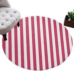 a round rug with pink and white stripes on it next to a chair, potted succulents and a plant