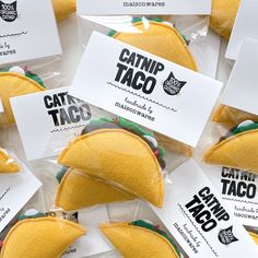 taco sandwiches wrapped in plastic wrappers on top of each other with cards attached to them