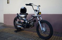 a motorcycle parked next to a building with a helmet on it's back tire