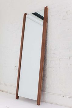 a white and brown mirror sitting next to a brick wall