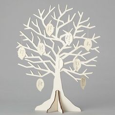 a white wooden tree with family names hanging from it's branches and two hearts attached to the leaves