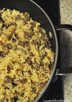 a pan filled with rice and meat on top of a stove