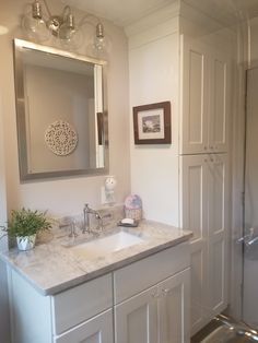 a bathroom with a sink, mirror and shower