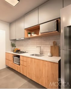 a modern kitchen with stainless steel appliances and wood cabinetry is pictured in this image