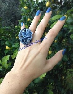 a woman's hand with blue nail polish and a ring on her left hand