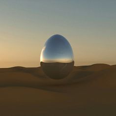 an egg shaped object in the desert at sunset