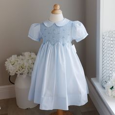 This New Feltman Brothers Smocked Blue Dress In Size 4t Is Adorable. The Sweet Peterpan Collar Is Trimmed In A Dainty Scalloped Embroidered Edge.The Short Puff Sleeves Are Banded At The Hem And Have A Matching Scalloped Embroidery. The Entire Bodice Is Smocked With A Gorgeous Petite Lattice Design With Two-Toned Blue Bullion Flowers, With White Seed Pearl Centers Spaced Throughout. The Back Has An Upper Button Closure And A Tieback Sash For A Perfect Fit. Timeless And Classy!! Brand New With Tag Fitted Blue Smocked Dress For Playtime, Blue Puff Sleeve Smock Dress, Blue Smock Dress With Puff Sleeves, Blue Cotton Smocked Playtime Dress, Short Sleeve Smocked Dress For Baptism, Blue Smocked Dress With Smocked Cuffs For Playtime, Blue Smocked Dress With Cuffs For Playtime, Blue Dress With Smocked Bodice For Playtime, Fitted Light Blue Smocked Dress With Smocked Cuffs