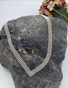 Stunning vintage sterling silver four row beaded ball chocker necklace with elegant V shape cut and secure lobster clasp!  The neckline of this chain sits just above the collar bone and is very elegant and striking. The necklace is made of solid silver ( stamped 925) and it's silver weight is 34.4 grams. This necklace would make an ideal gift for someone who enjoys simple timeless classic jewellery? Description - Length - 45 cm ( 18 inch approximately see photo for visual comparison)  Silver Weight- 34 grams  Box for presentation only and not included in the purchase.  All items are packed safely packed in bubble wrap, brown craft paper and packed in boxes with extra protection compostable packing pellets.. Thanks for looking 😃 Elegant Ball Chain Choker, Elegant Multi-strand Silver Choker, Elegant Silver Multi-strand Choker, Classic Silver Multi-strand Necklace, Formal Silver Round Bead Choker, Silver Choker With Round Beads For Formal Occasions, Formal Silver Ball Chain Jewelry, Formal Silver Choker With Round Beads, Elegant Ball Chain Choker Gift