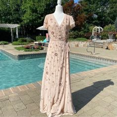 a dress that is sitting on top of a mannequin near a swimming pool