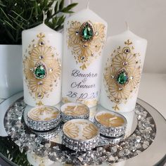 the wedding candles are decorated with gold and green jewels, which also include emeralds