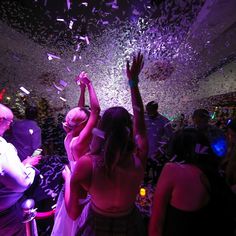 people dancing at a party with confetti in the air