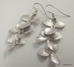 These silver orchid earrings are so sophisticated, delicate and simply stunning. They are perfect for any occasion and they make a wonderful bridal gift - for the bride or the bridesmaids! These earrings feature three lightweight, cascading matte silver plated orchids. They are finished off with stainless steel ear wires, for those with sensitive ears. The ear wires can be switched out to silver plated clip-ons, for those with non-pierced lobes. Simply select that option before adding to your ca Hypoallergenic Sterling Silver Flower Earrings For Wedding, Elegant Orchid Flower Earrings, Delicate Silver Flower Earrings For Wedding, Dainty Silver Flower Earrings For Wedding, Elegant Nickel-free Flower Earrings For Wedding, Silver Flower Drop Earrings For Bridesmaid Gift, Delicate Hypoallergenic Flower Earrings For Wedding, Dainty Silver Bridal Earrings For Bridesmaid Gift, Silver Dainty Bridal Earrings For Bridesmaid Gift