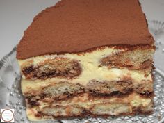 a piece of cake sitting on top of a glass plate covered in chocolate and white frosting