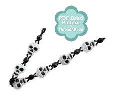 a black and white beaded necklace with skulls on it's side, in the shape of a flower