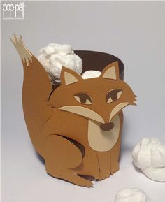 an animal made out of paper sitting next to cotton balls