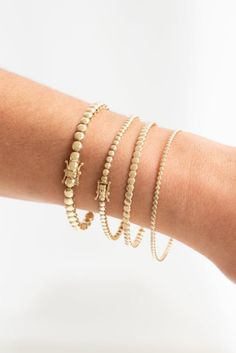 front view of a women's arm with the beaded bangles and bracelets on her wrist. Adjustable Stackable 14k Gold Bracelets, Stackable 14k Gold Cuff Bracelet For Everyday, Dainty Yellow Gold Bracelets With Spacer Beads, Minimalist Yellow Gold Bracelet With Spacer Beads, Everyday Stackable 14k Gold Cuff Bracelet, Everyday 14k Gold Stackable Cuff Bracelet, Stackable Yellow Gold Beaded Bracelets For Everyday, Dainty Stackable Beaded Bracelets In 14k Gold, Everyday Stackable Yellow Gold Beaded Bracelet