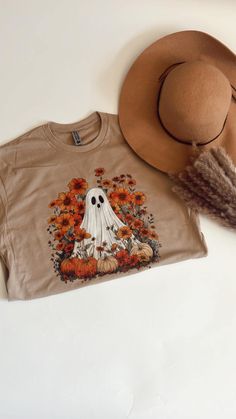 a brown hat and t - shirt with a ghost in the center on a white surface