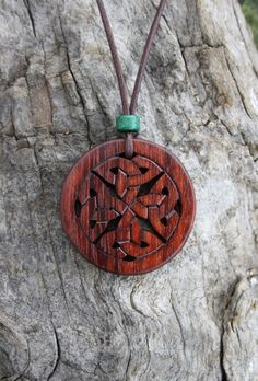 This very unique hand-carved Celtic knot necklace will be made for you, or a loved one, in my studio on the West of Ireland. This complex Celtic knot necklace features an off-cut of bubinga rosewood, recycled from musical instruments constructed by a local luthier. As a musician myself, I take enormous satisfaction in creating a piece of jewellery whose inherent wood has previously featured in a beautiful hand-made guitar. Also, part of rosewood's attractiveness is its durability and ability to Brown Carved Round Pendant Necklace, Artisan Carved Medallion Necklace, Traditional Mahogany Jewelry As Gift, Traditional Mahogany Jewelry For Gifts, Traditional Handmade Mahogany Jewelry, Celtic Infinity Knot, Irish Knot, Celtic Jewellery, Celtic Knot Necklace