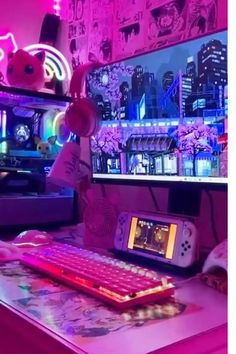 a desk with a keyboard, mouse and monitor on it in front of a pink wall