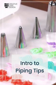 three metal cones sitting on top of a white table next to colorful confetti