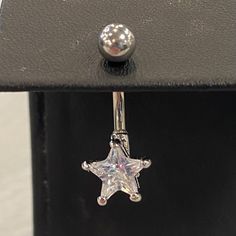 a pair of silver earrings with a star on the end and a ball in the middle