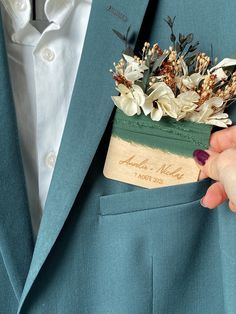 a person wearing a blue suit and holding a flower arrangement in their lapel pocket