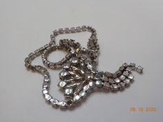 "Gorgeous vintage rhinestone choker necklace. 14\" prong set rhinestone chain with flip over clasp. Rhinestone pendant is 1 1/2\" x 2 1/2\" including the three dangling portions. Loaded with clear rhinestones, all of which are present and intact. Gorgeous sparkle!! NOTE: There is one tiny rhinestone missing on the clasp....otherwise, excellent condition." Costume Jewelry Rhinestone Pendant Necklace, Formal Rhinestone Pendant Necklace, Vintage Rhinestone Chain Necklace For Parties, Vintage Rhinestone Pendant Necklace For Party, Vintage Crystal Rhinestone Choker Necklace, Vintage Crystal Rhinestone Necklace, Vintage Silver Rhinestone Necklace, Vintage Metal Rhinestone Necklace With Chain, Vintage Metal Rhinestone Necklace