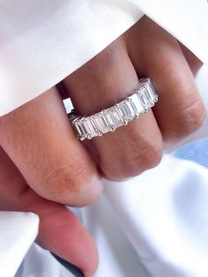 a woman's hand wearing a ring with three baguettes on it,