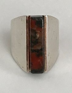 This ring unites quiet strength with sophisticated simplicity. A rectangular agate column, just short of 1" in length and 1/4" wide, makes up the center of this eye catching ring. It's held in by the silver frame which starts out the same length as the stone and tapers off in the back and turns into a comfortable band. It is signed inside the band. The Henning Ulrichsen jewelry company was established in Denmark in 1951 and is still in existence and being run by the second generation. This ring Modern Rectangular Gemstone Ring, Unique Rectangular Rings With Natural Stones, Unique Rectangular Gemstone Ring, Elegant Rectangular Natural Stone Rings, Elegant Rectangular Rings With Natural Stones, Unique Rectangular Natural Stone Rings, Contemporary Rectangular Jewelry For Formal Occasions, Contemporary Formal Jewelry With Rectangular Shape, Contemporary Formal Rectangular Jewelry