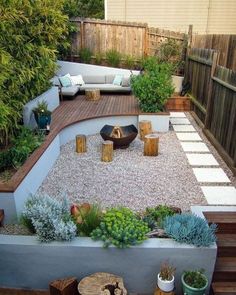 an outdoor garden with gravel, rocks and wooden benches in the center is surrounded by plants