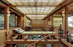 the inside of a building with wooden floors and railings on each floor, looking down at an indoor swimming pool