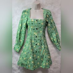 This Listing Is For A Nwt Blackmilk Animal Crossing New Horizons Isabelle Gingham Pilgrim Dress. It Has Isabelle's Signature Gingham Print With Little Isabelles, Leaves And Daisies Sprinkled About. Its A Size 8 And Measures About 15.5'' From Pit To Pit, About 18'' From Pit To Cuff And About 33'' From The Top Of The Back Of The Collar And To The Bottom Him. It Has A Zipper Closure In Back, Cute, Non-Fuctional Buttons On Front And Functional Buttons On The Cuffs. If You Have Any Questions Or Would Green Mini Dress For Picnic, Green Floral Print Dress For Picnic, Green Floral Print Dresses For Picnic, Square Neck Plaid Dress For Picnic, Green Floral Print Dresses For Picnics, Plaid Mini Dress For Brunch, Casual Gingham Long Sleeve Dress, Casual Long Sleeve Gingham Dress, Green Square Neck Dress For Picnic