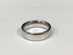 a silver ring on a white surface with no one in the photo to describe it