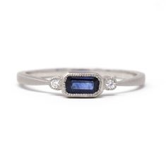 a white gold ring with a blue sapphire and diamonds