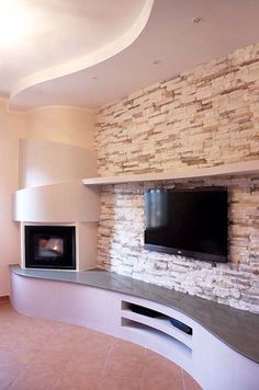 a living room with a stone fireplace and flat screen tv