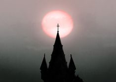 the sun is setting behind a church steeple