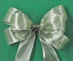 a green box with a silver bow on the top and bottom, against a green background