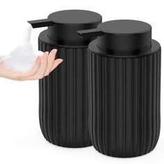 two black trash cans with one being used as a soap dispenser and the other is holding a white hand