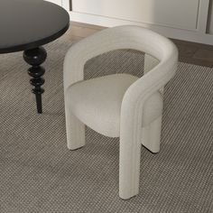 a white chair sitting next to a black table on top of a carpeted floor