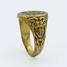 This Art Nouveau era yellow gold ring, dated inside 1900, is a fine example of the period's aesthetic, which often included fluid, organic forms and mythological motifs. The band features a figural depiction of Medusa, a nod to the era's fascination with Greco-Roman themes and figures, finely crafted from 15 karat yellow gold ring size 5 3/4, weighs 9.6 grams. The face of the ring presents a monogram or inscription, typical of personalization in jewelry of this time. Art Nouveau jewelry often reflected a departure from the rigid forms of the Victorian era, embracing instead the flowing lines and natural forms that have come to define the movement. All of our pieces are in as found condition, we just lightly clean them never polish, polish only upon request which nullifies the return option Antique Yellow Gold Signet Ring, Victorian Engraved Yellow Gold Ring For Ceremonial Occasion, Victorian Yellow Gold Engraved Ring With Intaglio, Victorian Engraved Yellow Gold Ring With Intaglio, Antique Yellow Gold Engraved Ring Collectible, Victorian 14k Gold Intaglio Engraved Ring, Antique Engraved Yellow Gold Ring Collectible, Antique Yellow Gold Engraved Ring, Collectible, Heirloom Ceremonial Yellow Gold Engraved Ring