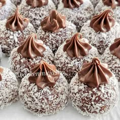 chocolate covered donuts are sitting on a white tablecloth with some drizzled in them