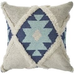 a blue and white pillow with fringes on the sides, in front of a white background