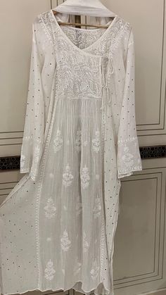 Discover the epitome of timeless elegance with our Pure Cotton Silk Angarkha Set, adorned with vintage Chikankari Ek Taar embroidery. This exquisite piece is further embellished with intricate Mukaish and Pitta work, creating a luxurious blend of tradition and modernity. The kurta comes with a matching dupatta and lining, and you have the option to choose between churidhaar or pants for the bottoms, allowing you to tailor the set to your personal style. Each set is customizable to any size, ensuring a perfect fit for everyone. Please send your size specifications before placing your order. Embrace the allure of heritage craftsmanship with this stunning ensemble, perfect for any special occasion. Elegant Salwar Kameez With Cutdana For Festive Season, Elegant Embroidered Floor-length Fabric For Diwali, Elegant Floor-length Embroidered Fabric For Diwali, Elegant Salwar Kameez With Cutdana For Eid, Festive Elegant Salwar Kameez With Cutdana, Elegant Cutdana Salwar Kameez For Eid, Long Sets With Intricate Embroidery, Elegant Semi-stitched Kurta With Cutdana, Elegant Semi-stitched Kurta With Cutdana Detail