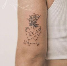 a woman's arm with a tattoo on it that says stay strong and flowers