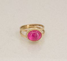 Beautiful bright pink tourmaline set in 18K Gold with handmade 14K Gold double band.  This pink tourmaline has a beautiful hot pink hue and is "eye clean" .  The stone lights from within!  It reminds me of peonies blooming in my garden.  This is by far the prettiest Tourmalines I've ever seen!  I hand fabricated the elegant and sturdy double band made in 14K Yellow Gold.  I really like the open space surrounding the Tourmaline which is set horizontal a.k.a east to west setting.  The setting is backed in Argentium Sterling Silver.  The ring is One of a Kind and signed! US Size 8.75 .  Complimentary resizing is available.  Please leave a note if you need a different size and allow up to one week. Note, resized rings can not be returned.    Materlials: Rubellite Tourmaline cabochon 12mm x 11m Peonies Blooming, Resize Ring, Rubellite Tourmaline, October Birthstone, Jewelry Ring, October Birth Stone, Gold Set, Pink Tourmaline, Open Space